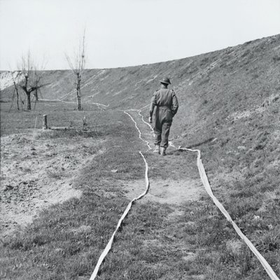 White tape marking clear tracks through a minefield by the River Senio, Italy, March 1945 by English Photographer